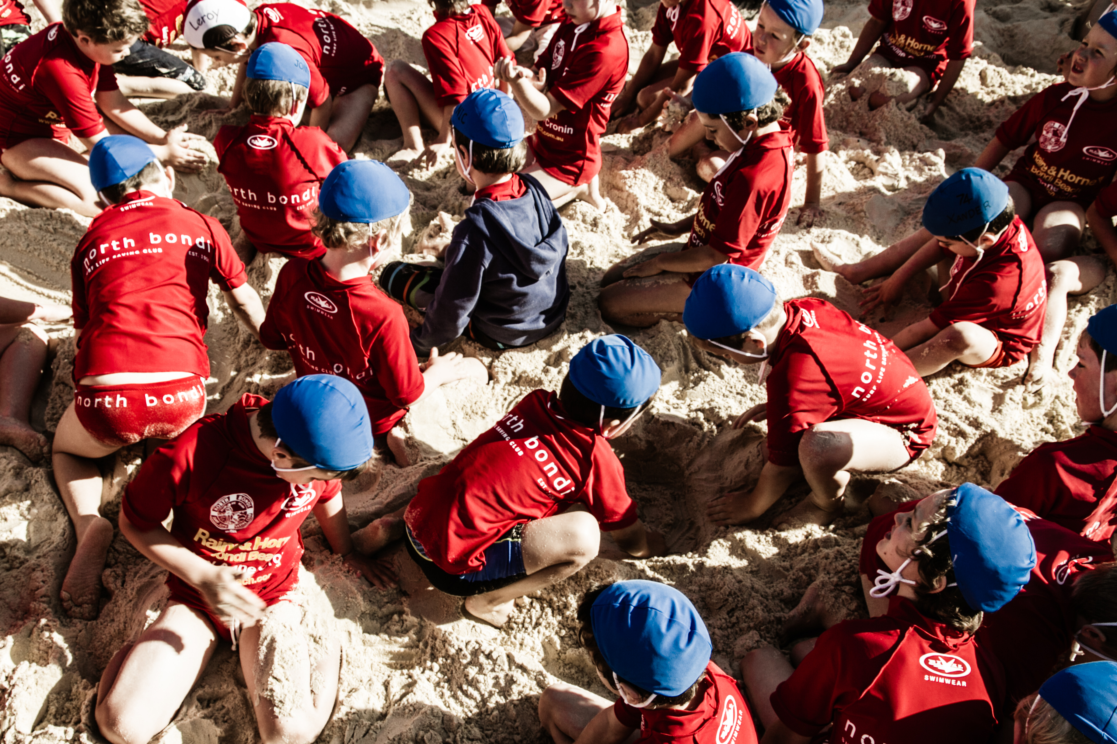 Children with their nippers uniforms playing on the sand