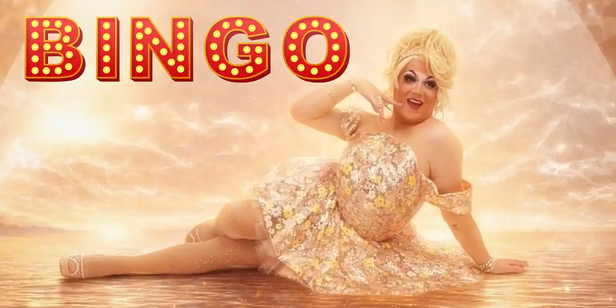 An photoshopped image of a drag queen in a shiny yellow dress and blonde wig smiling and stretching out on the shore of a beach, against a brilliant sunset. To her left is the word "BINGO" in all capital letters in a bright, show-style font.