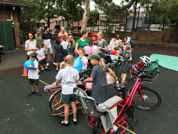 Students and parents in playground with bikes