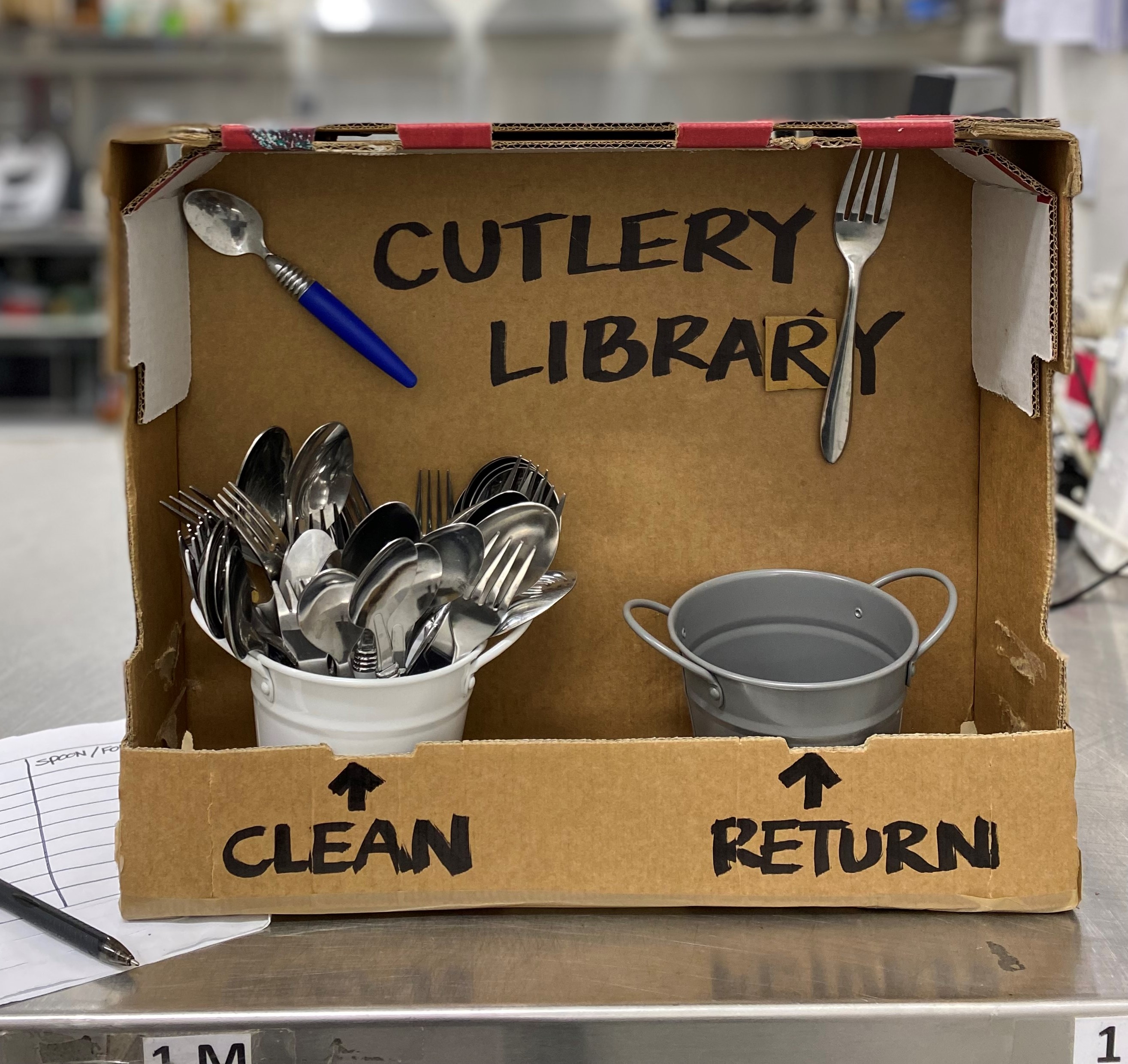 DIY box on its side with containers for knives and forks